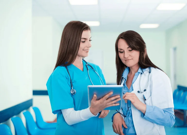 02 female doctors checking their tablet device