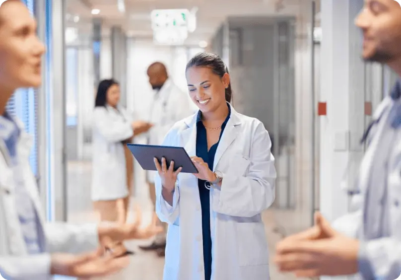 A doctor smiling and checking her tablet