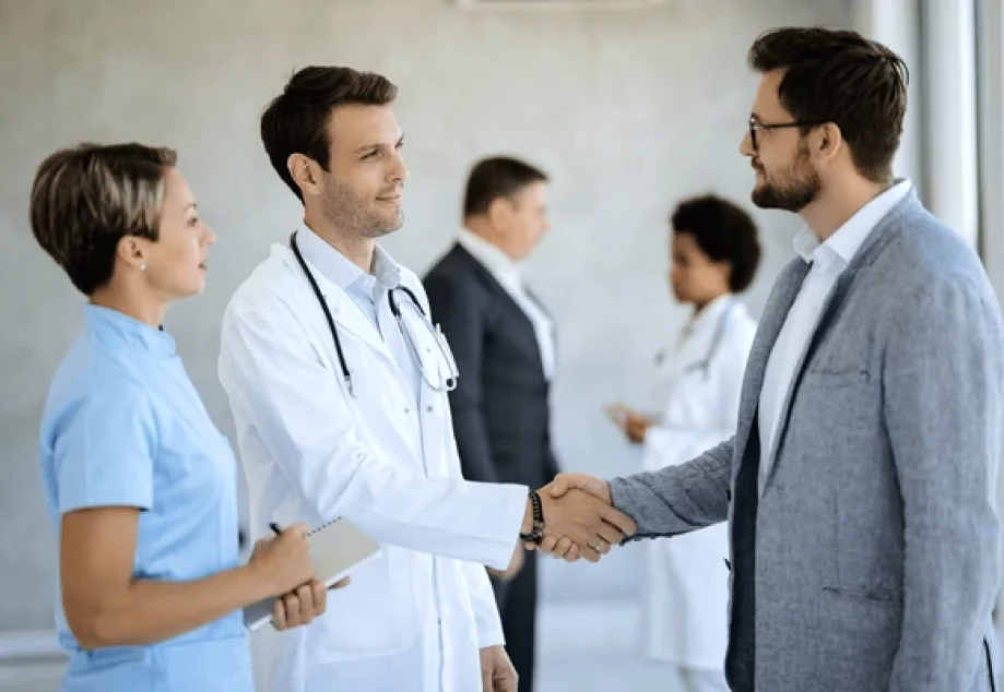 A doctor and professional man shaking hands