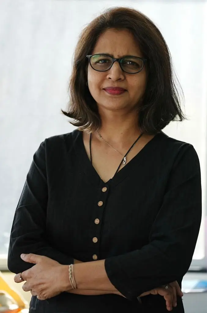 Portrait of a woman doctor in a black dress with arms crossed, standing confidently