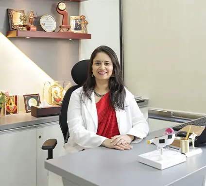 Female doctor sitting at her clinic desk smiling