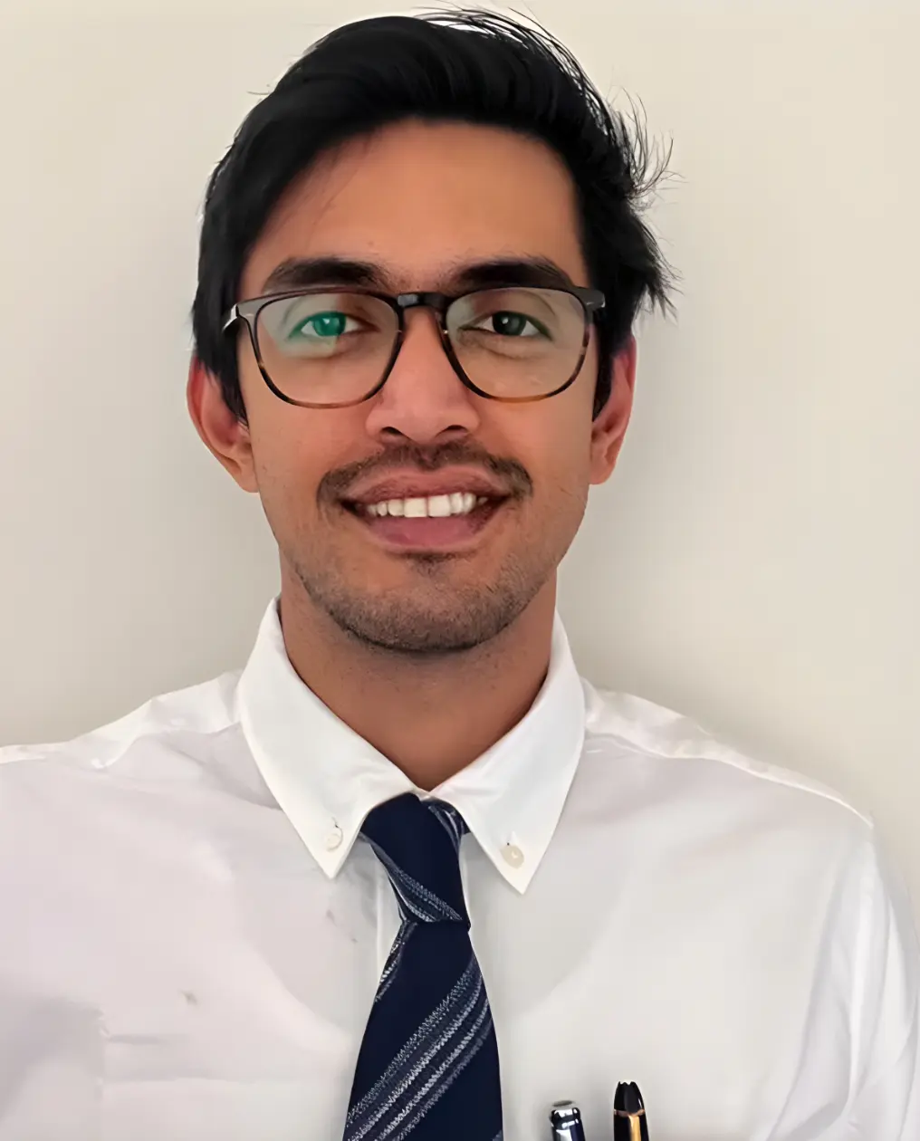 Plastic surgeon in formal attire wearing glasses and a tie