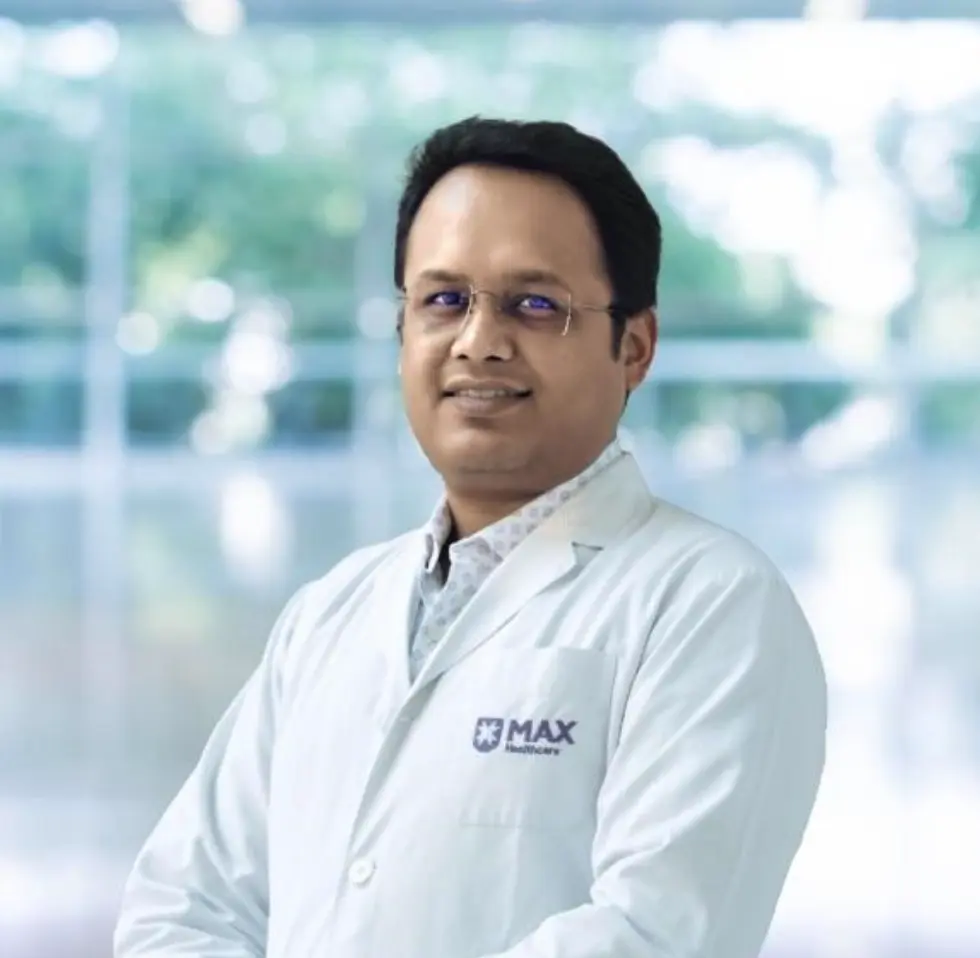 Dr. Ashish Anand, general and minimal access surgeon, in a white coat with a Max Healthcare logo