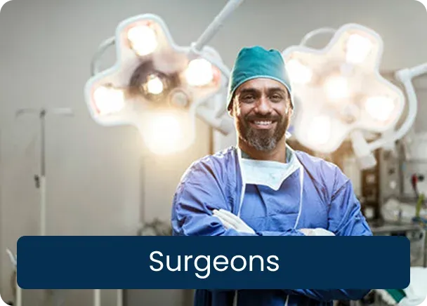 Surgeons: a smiling surgeon in blue scrubs and a green cap with arms crossed in an operating theatre